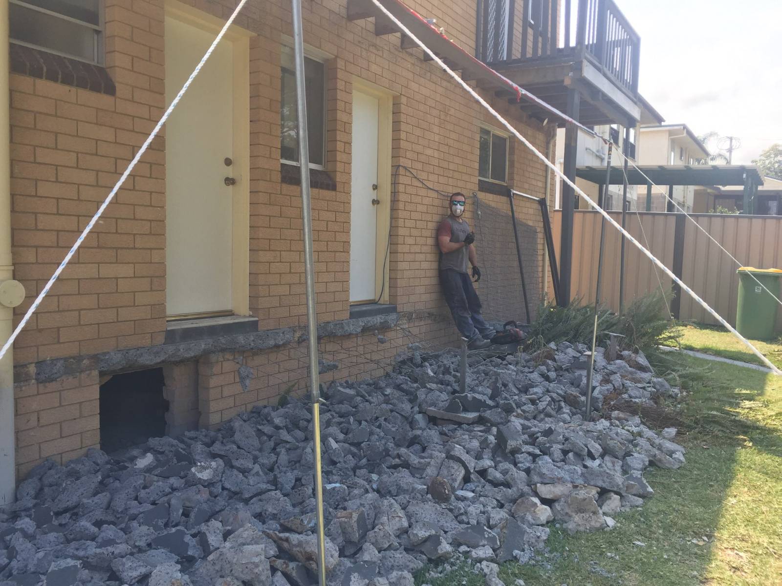 Grinding concrete flush with brick wall